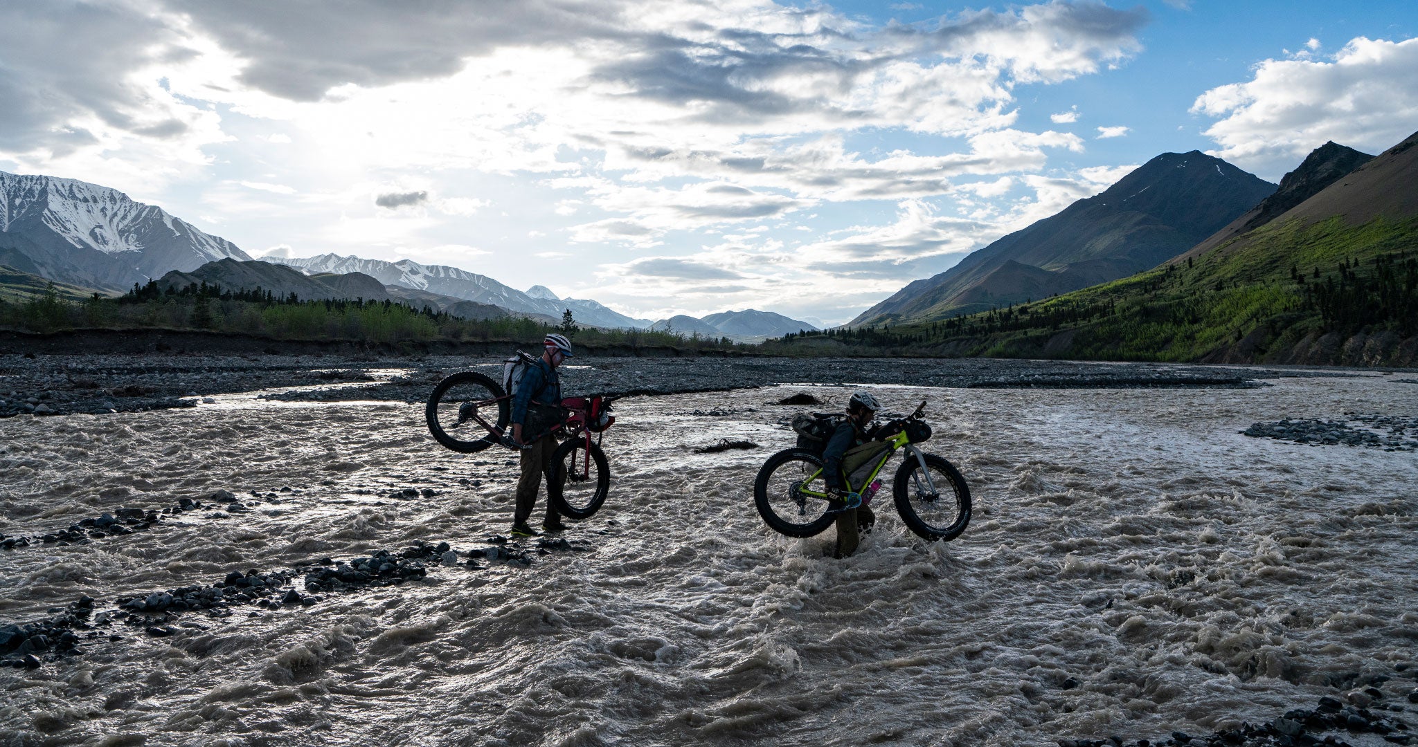 Bikepackers crossing a flooding river
