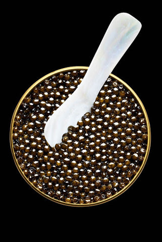 using the spoon made of mother-of-pearl to take some caviar