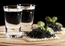 vodka is next to caviar on a biscuit 