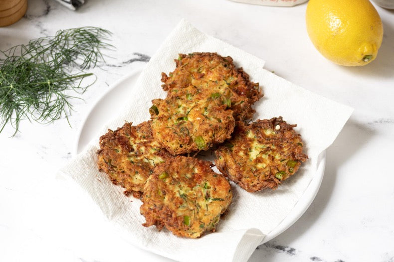 Crispy Zucchini patties resting on a paper towel in a stack