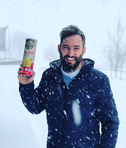 Matt smiling, holding a good crisp canister in falling snow