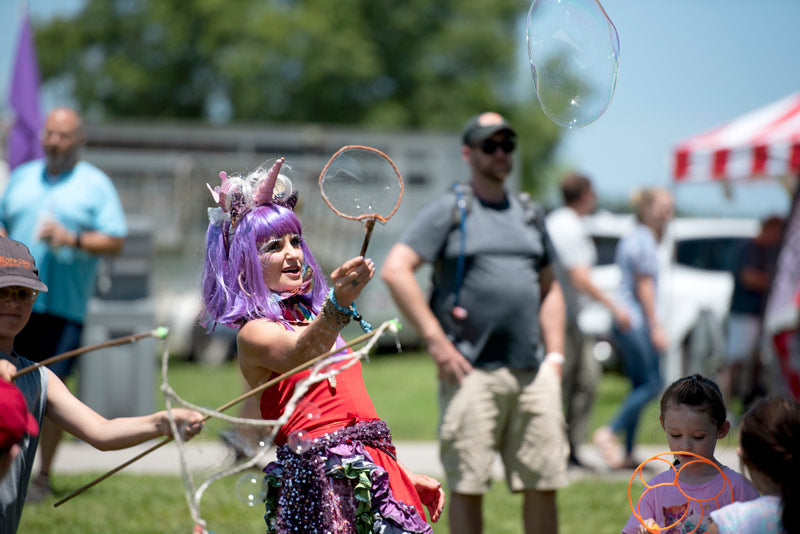 Circus performer playing with bubble wands