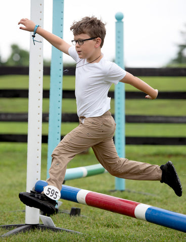 A child leaping over a jump