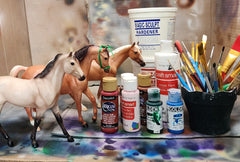 various art supplies and two model horses