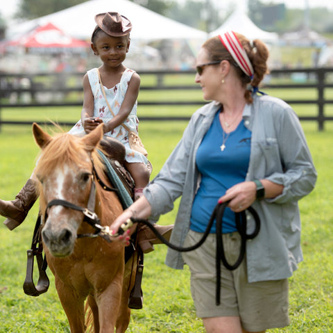 A girl riding a pony at BreyerFest