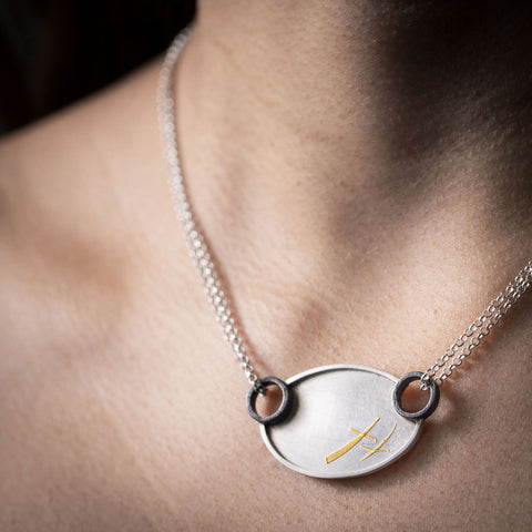 Zink Metals’ XOXO Necklace: Silver and Gold is a trendy statement pendant necklace for fall 2023