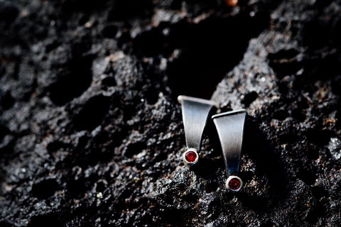 the Aurora Earrings showcase mixed materials of steel, sterling silver and garnets