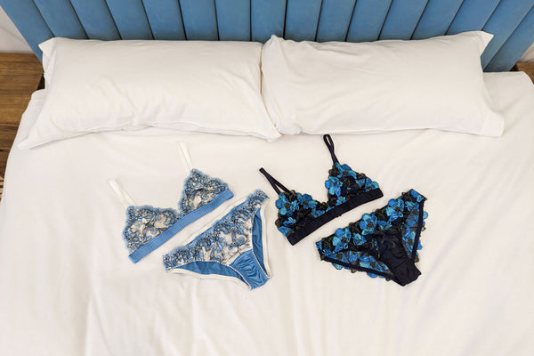 Luxury lingerie sets on a hotel bed in blue embroidery