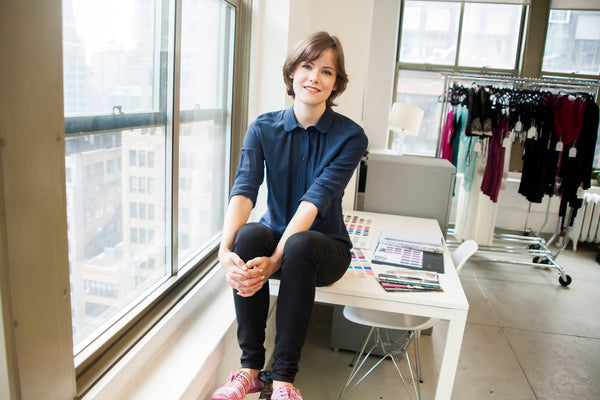 Lingerie designer Angela Friedman, sitting in her New York City showroom with samples hanging behind her