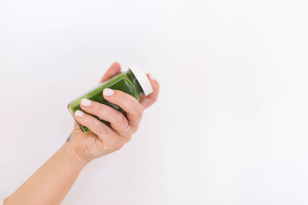 Mixing Matcha in a spice jar with a white lid