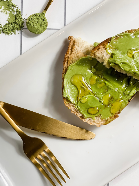 Piece of toast with green matcha butter and honey drizzle