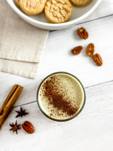 Pecan Pie Matcha Latte with Cinnamon and Pecans on the table and a bowl of Pecan Sandies at the top