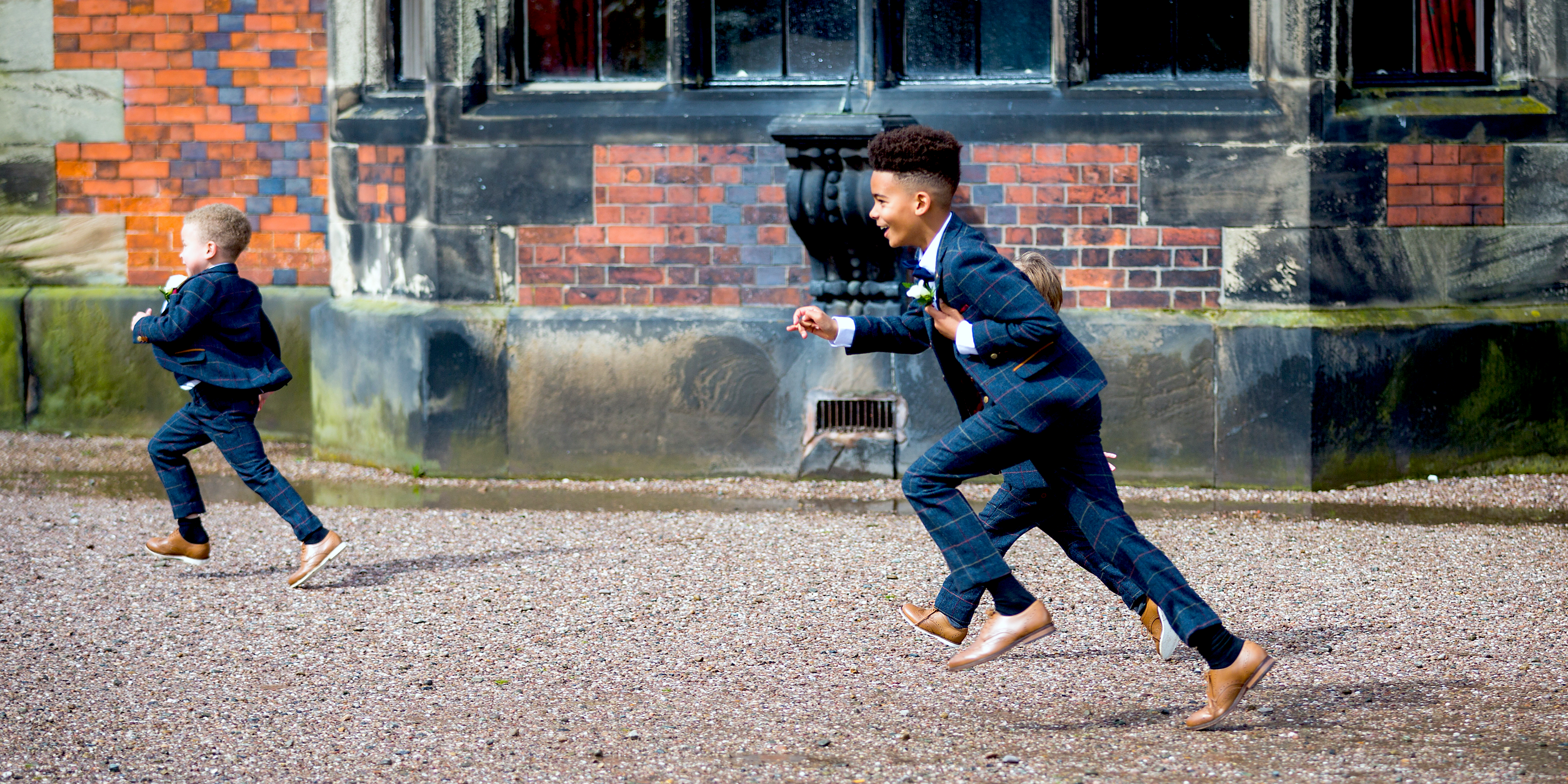 children running wearing boys blue tweed three piece suits