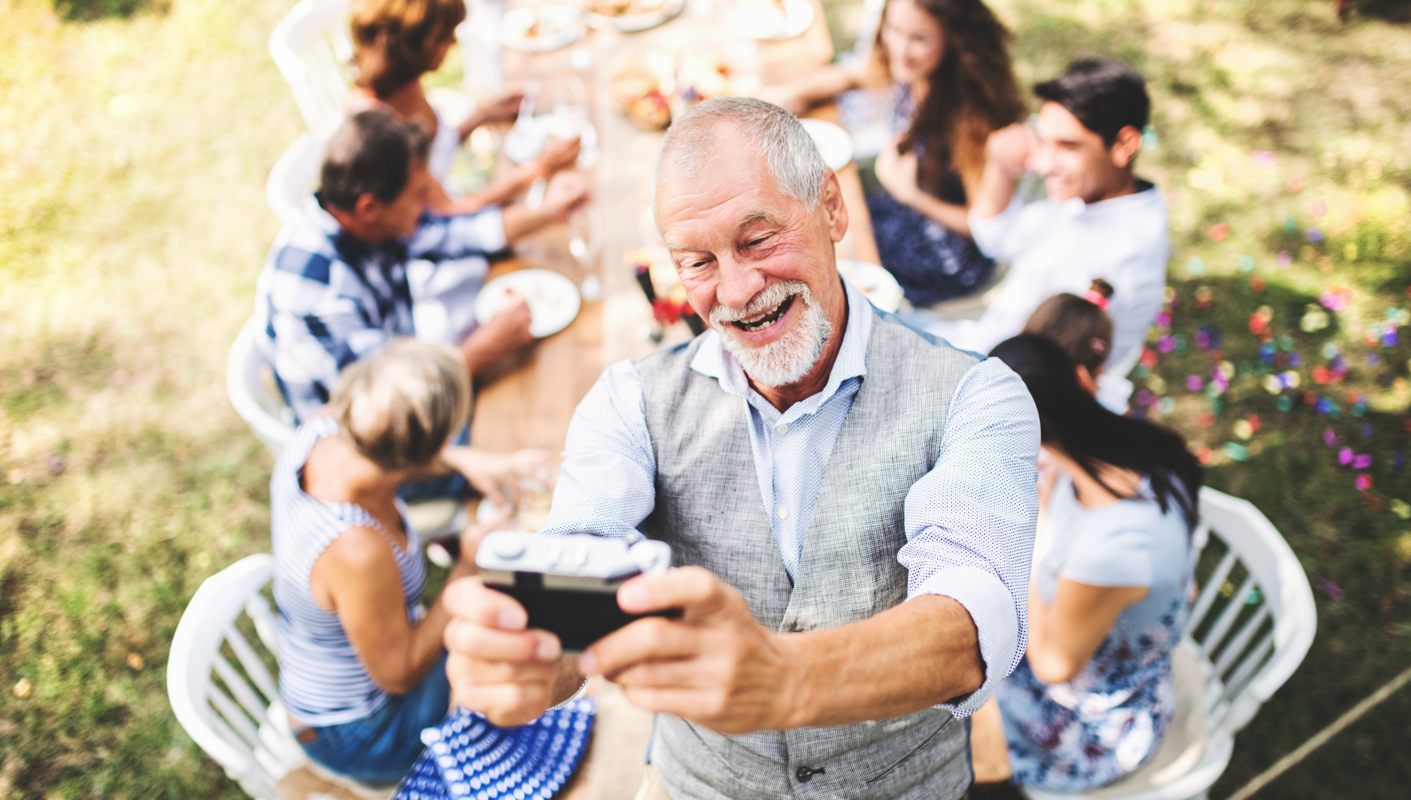 father happily takes a picture on a family gathering