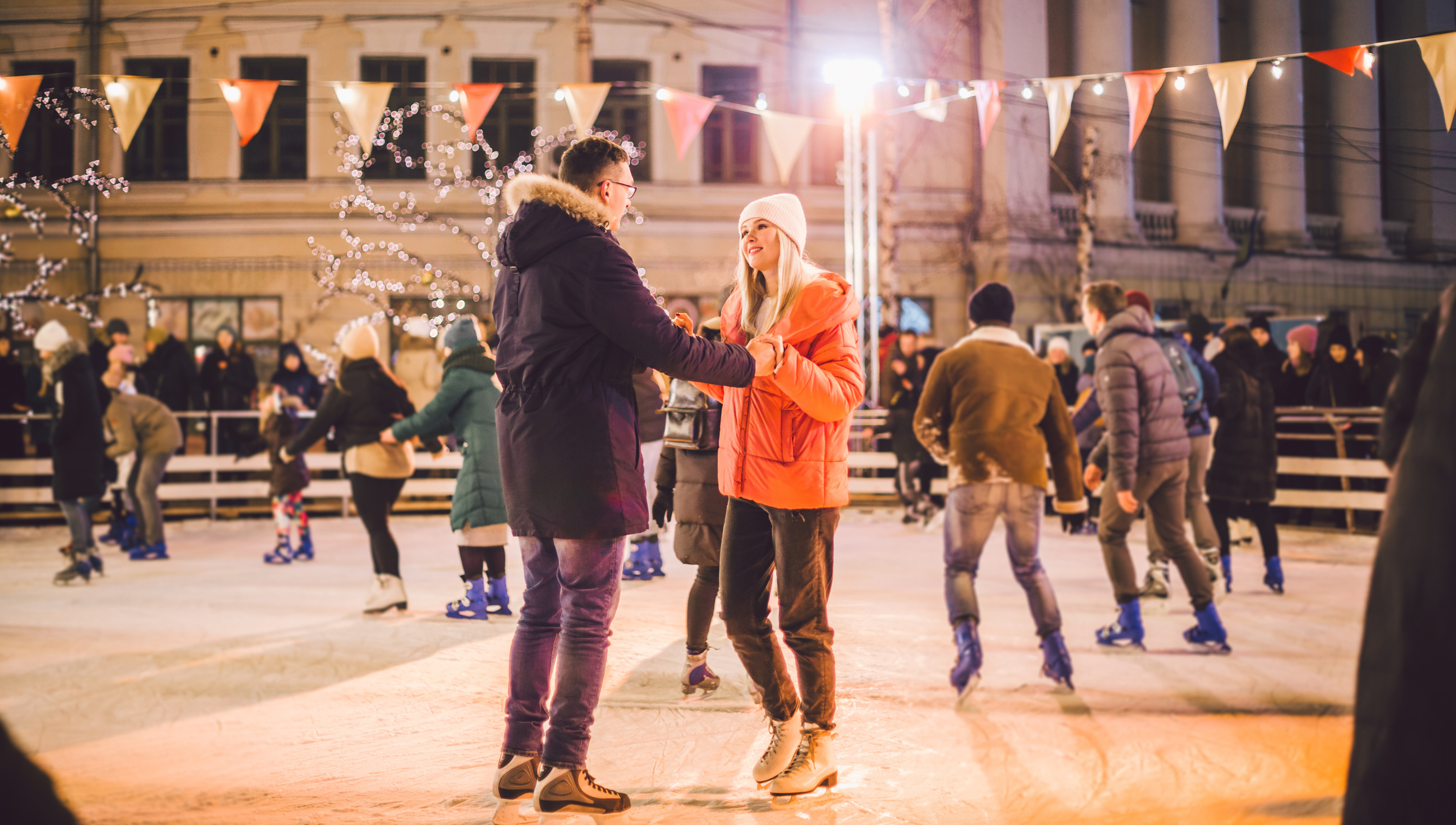 couple skiing on ice rink