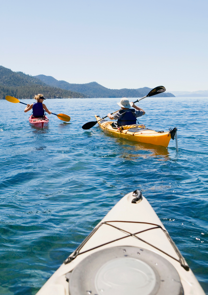 friends kayaking on calm lake