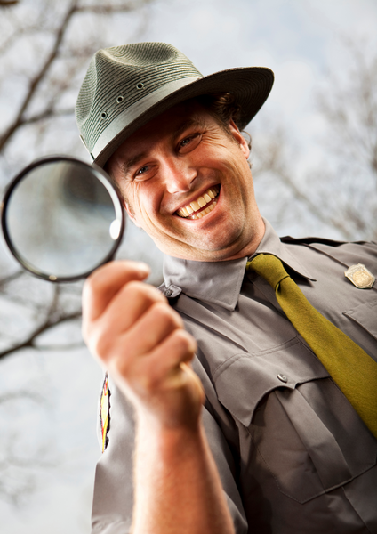 park ranger holding magnifying glass