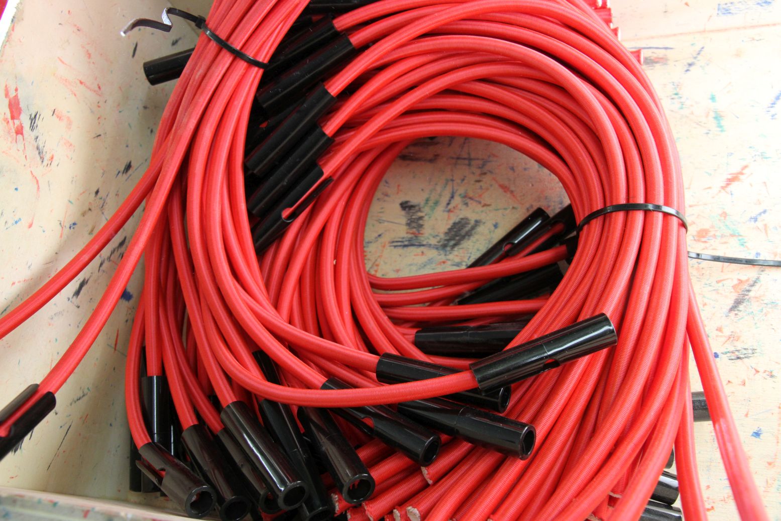 A pile of red tubing with black fasteners will be constructed in a Metalog Tools experiential learning activity or game