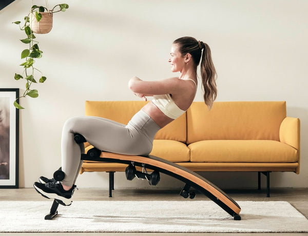 Une athlète féminine fait des redressements assis sur un banc de redressement assis