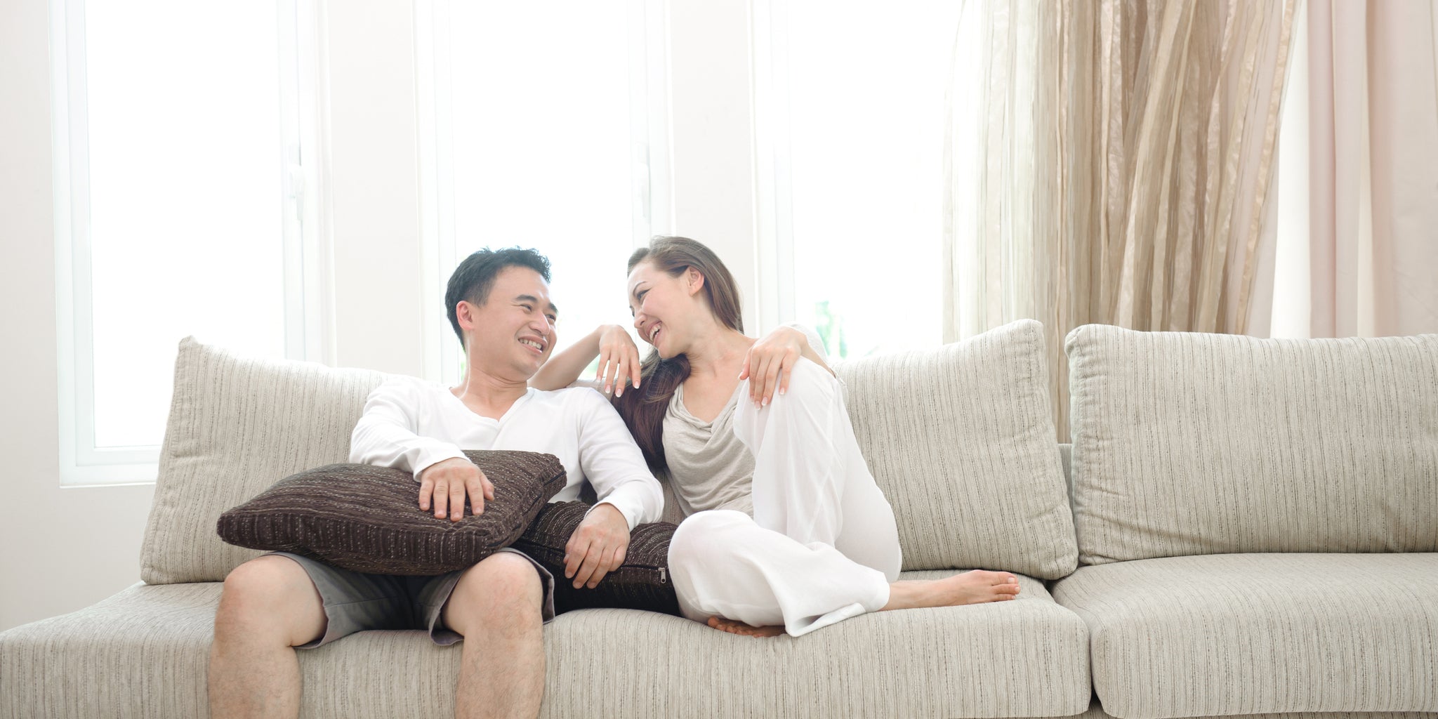 happy-couple-laughing-together-on-the-sofa