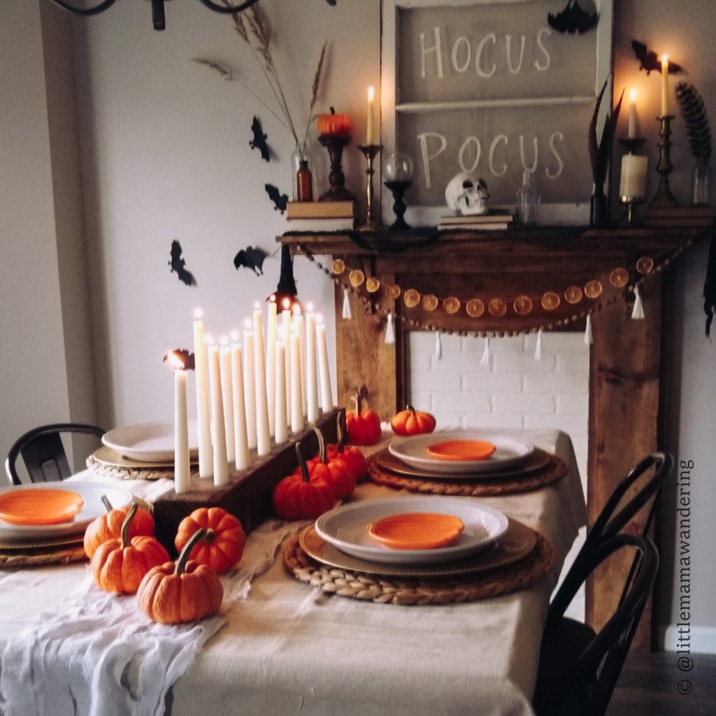 Wooden Candle Holder in front of a wooden mantle with halloween decor and lit candles.