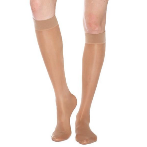 pair of legs wearing nude, sheer, knee-high compression socks