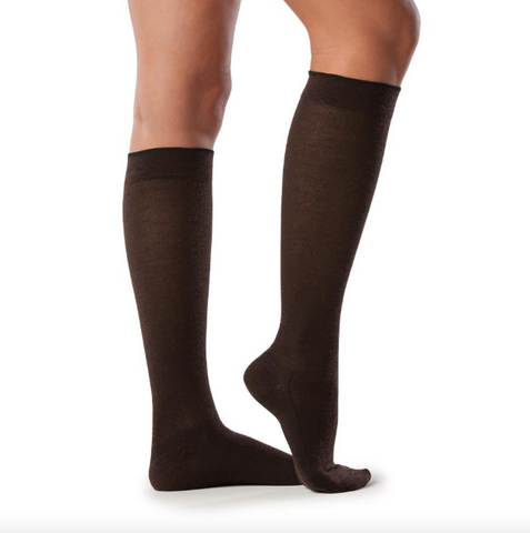 pair of legs wearing dark brown, knee-high compression socks