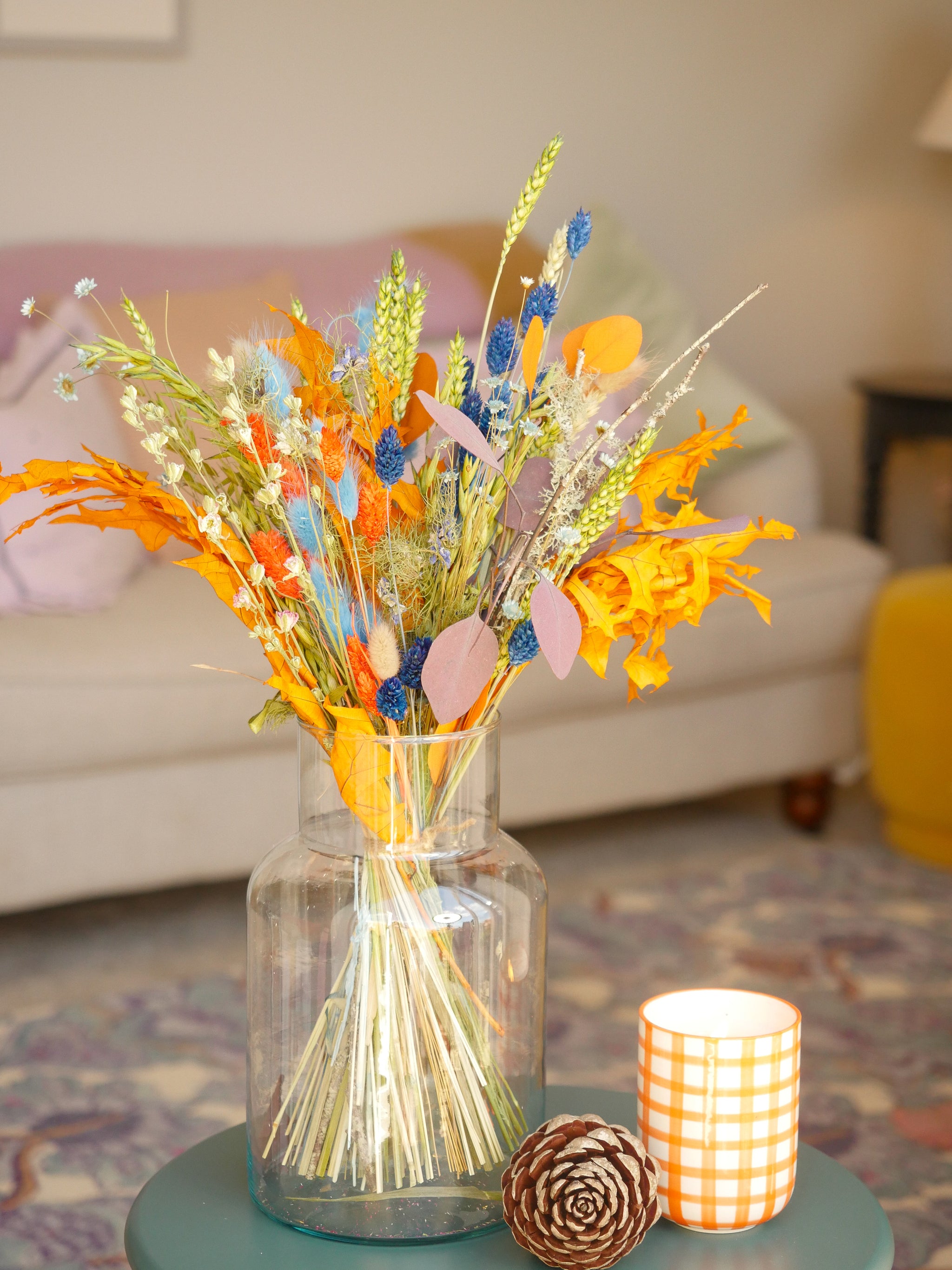 A dried floral bouquet in bright orange and blue from The Happy Blossoms, displayed in a vase