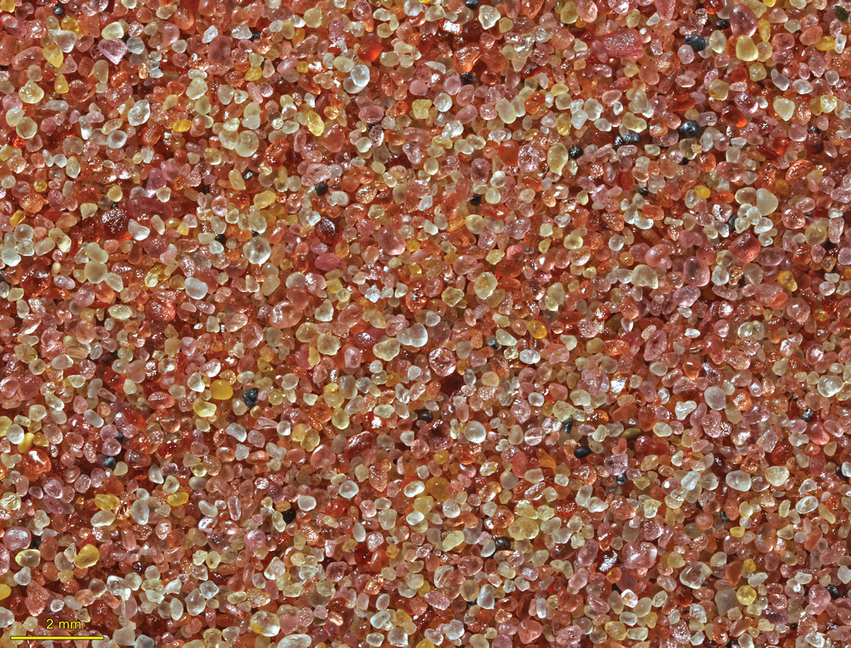 pink and yellow garnet sand under a microscope