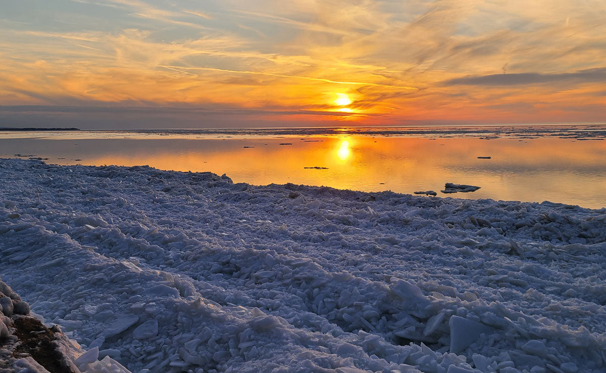 sunset over snow covered beach