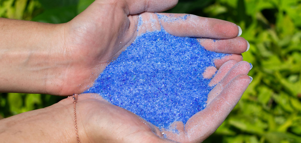 hand full of blue bottles made into sand