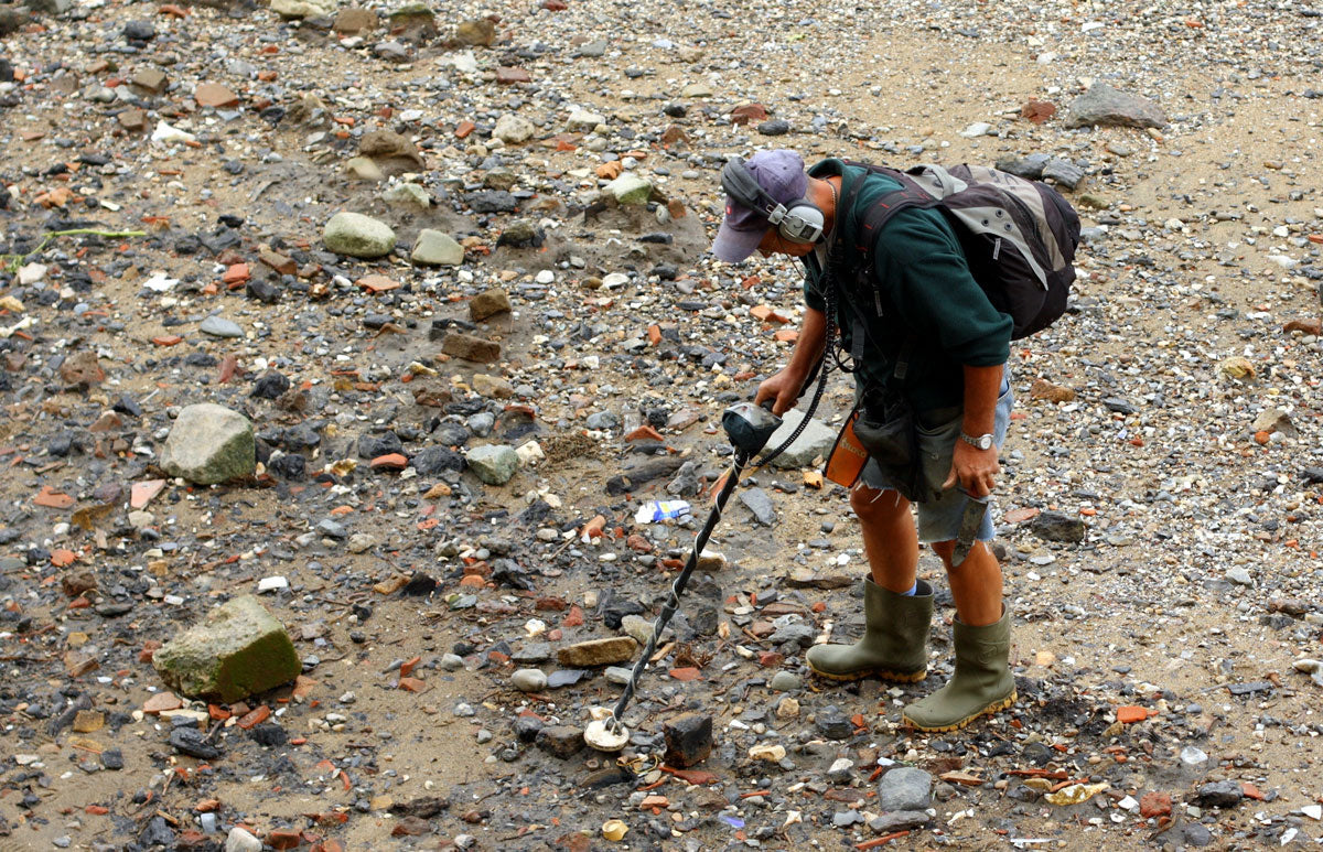 mudlark using a metal detector