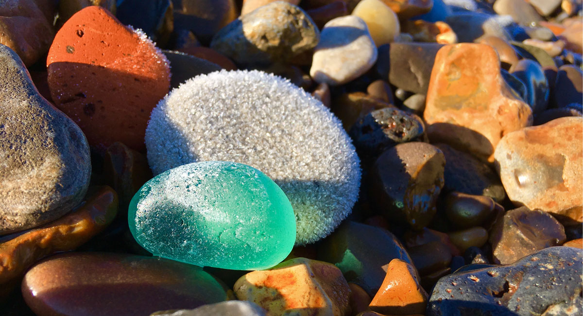 sea glass and frosty rocks on winter beach in canada