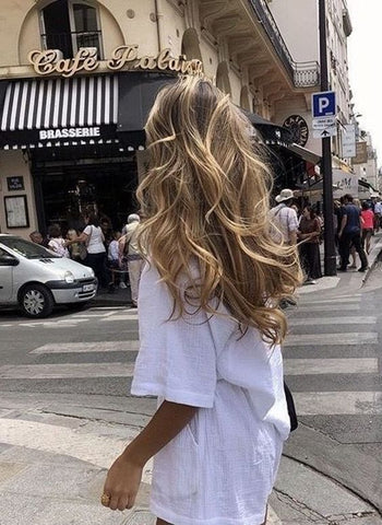 blonde women walking the streets on france with a curly bouncy blowout styled hair