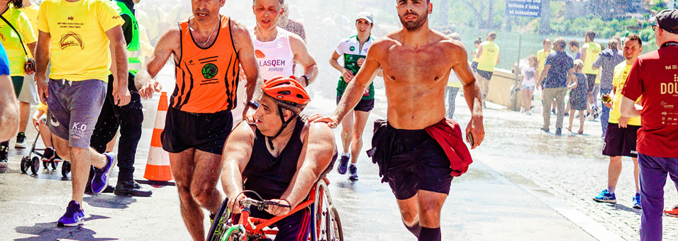 People running a marathon including one on a racing wheelchair