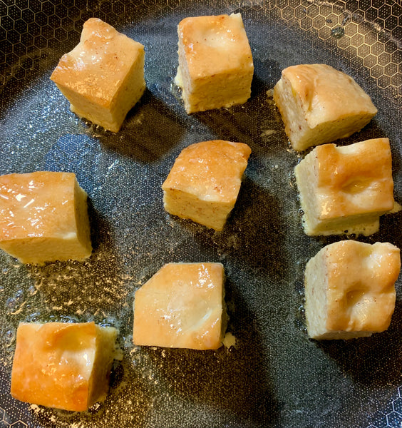 Thumb Bread cut into squares baking in a buttery pan