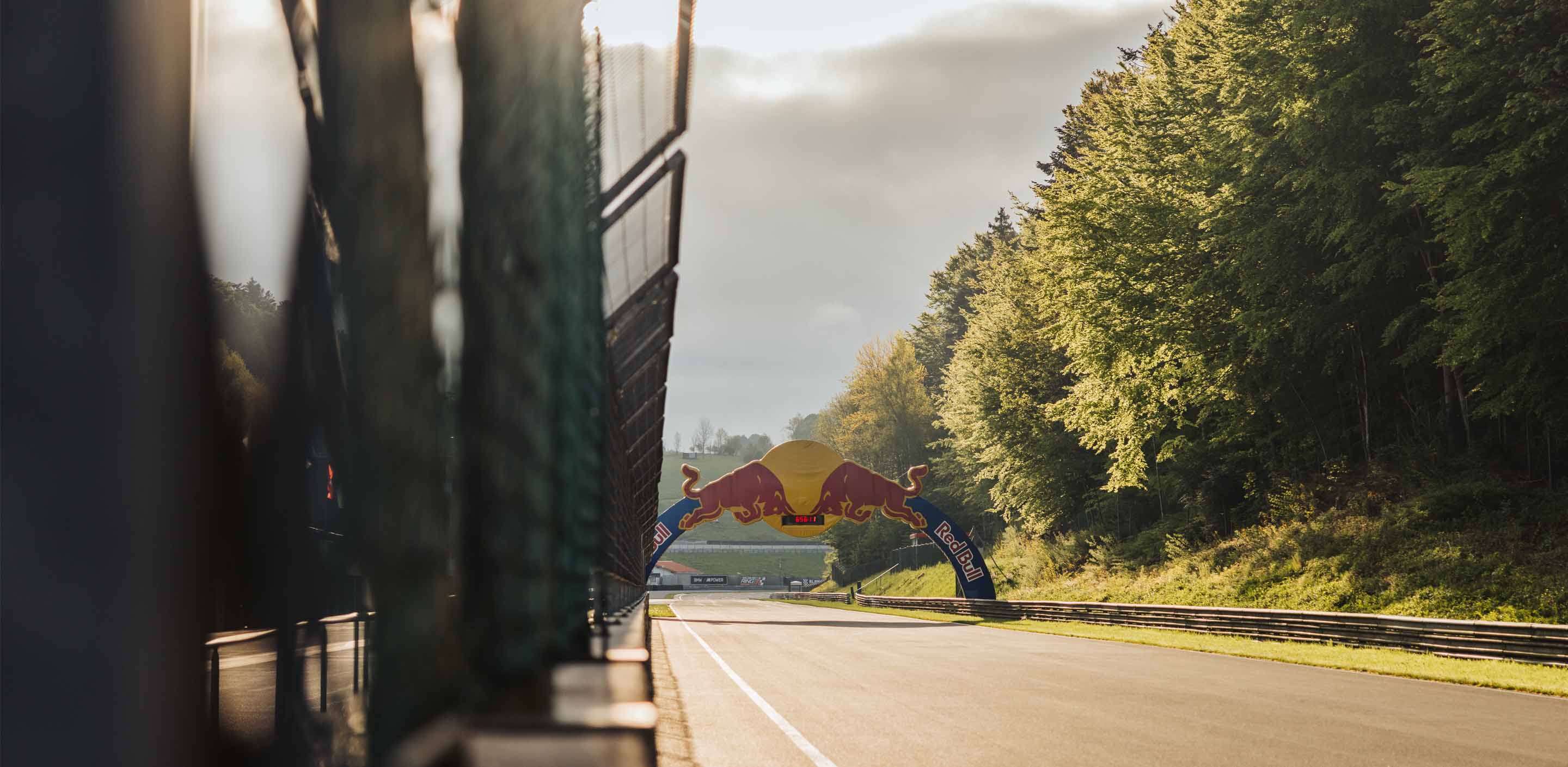 Early morning atmosphere at the main straight of Salzburgring during a GP Days Open Pitlane Track Day with view on the Red Bull Arch including a clock showing 6:55am