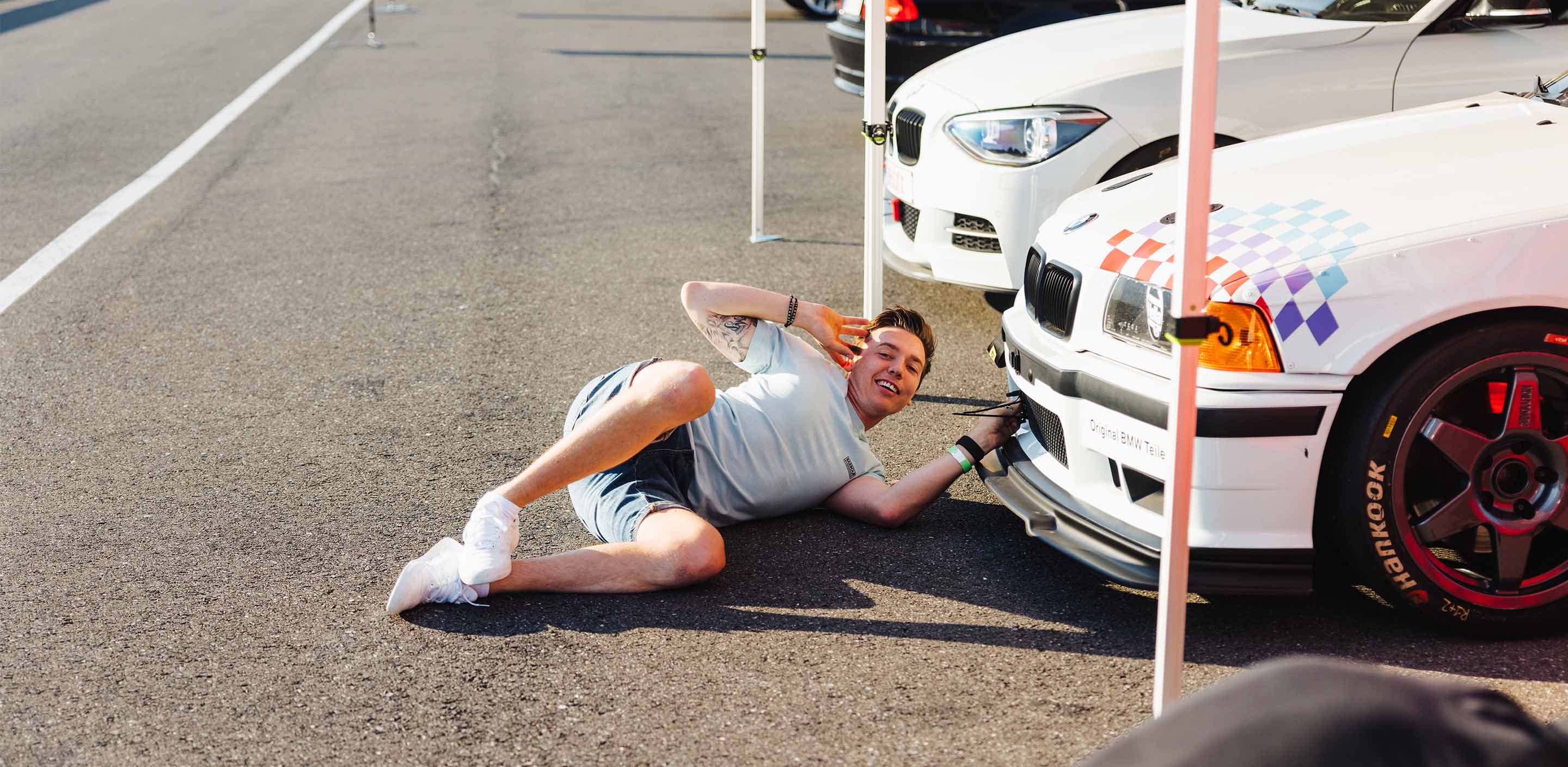 A man working on his BMW E36 M3 during a GP Days Open Pitlane Track Day at Bilster Berg