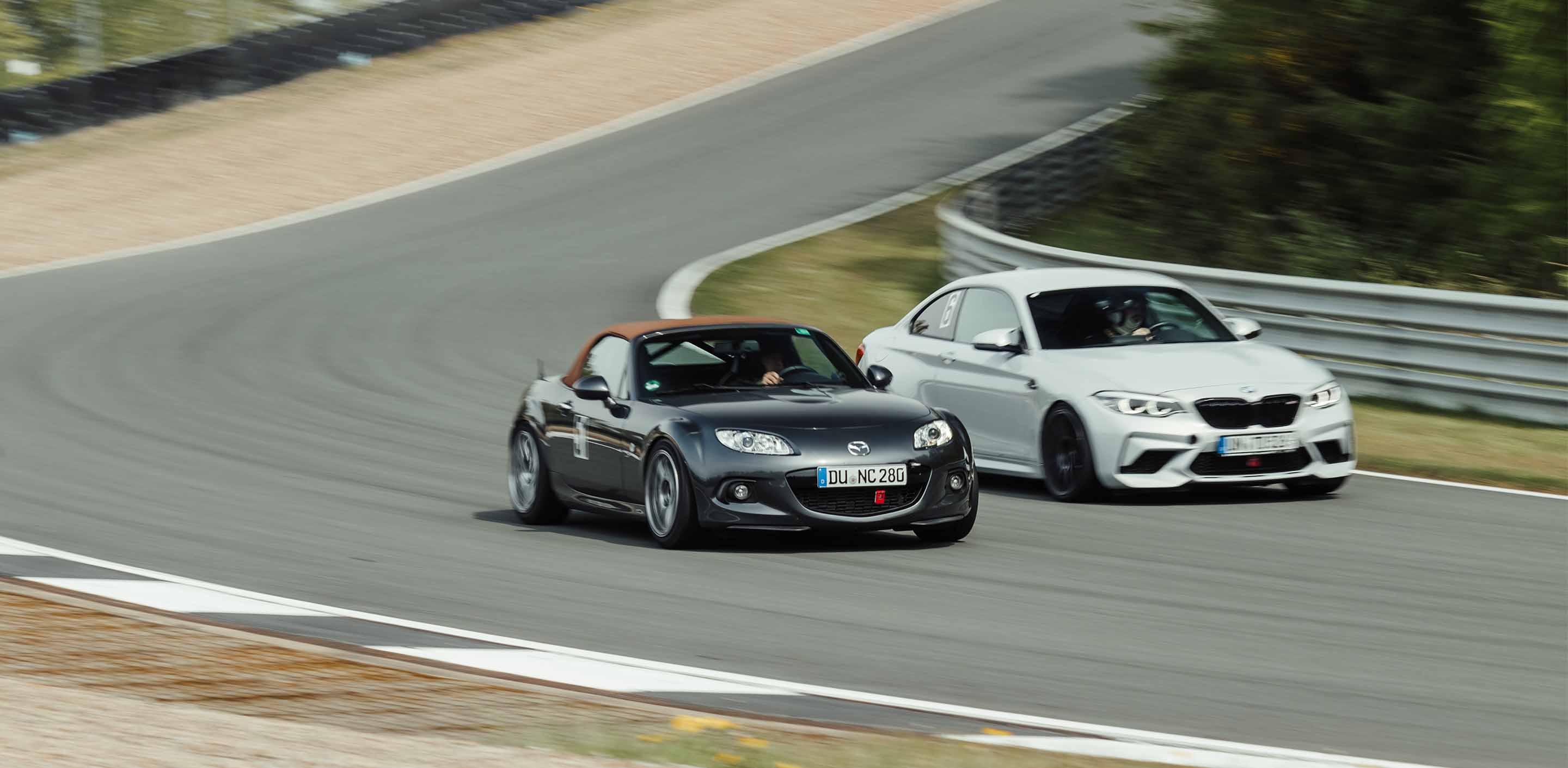 A BMW M2 is overtaking a Mazda MX5 during a GP Days Open Pitlane Track Day at Bilster Berg