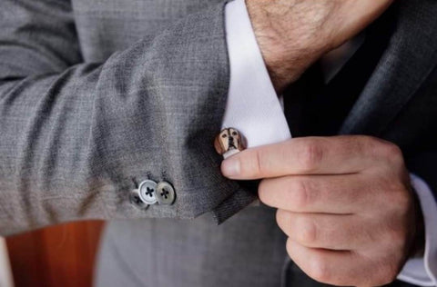 Groom putting his cufflink in and it's a clay mould of his dog