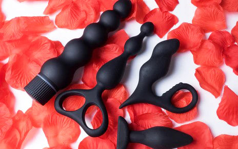Collection de plugs anaux noirs en silicone sur roses rouges-Luckyprize