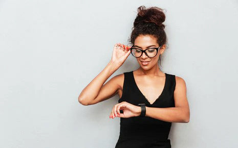 Femme à lunettes habillé en noir regardant l'heure sur sa montre-Luckyprize
