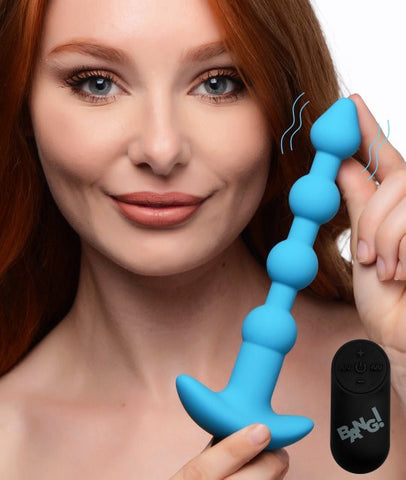 Femme rousse tenant un plug anal en silicone bleu dans les mains-Le Royaume Du Plug