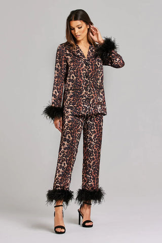 Woman wearing leopard print pajamas with black feather trim