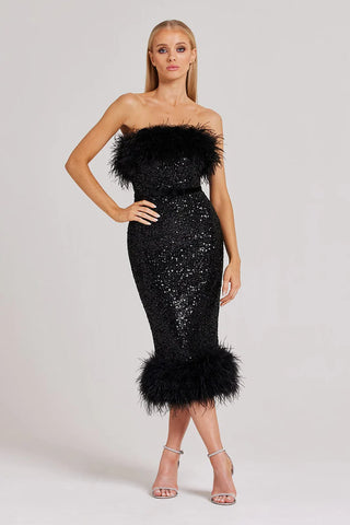 Woman wearing strapless black dress with sequin detailing and feather trim
