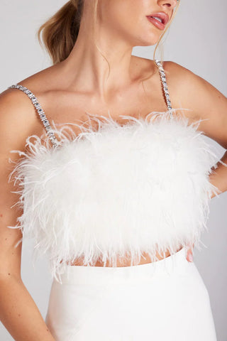 A woman wearing a feather top with diamante straps
