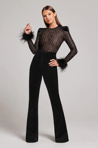 A woman posing wearing a lace and velvet jumpsuit