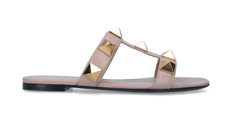 pink leather valentino stud sandals with gold studs and a short heel sat against a white background