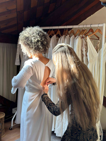 Bridal consultant adjusting a bride's dress