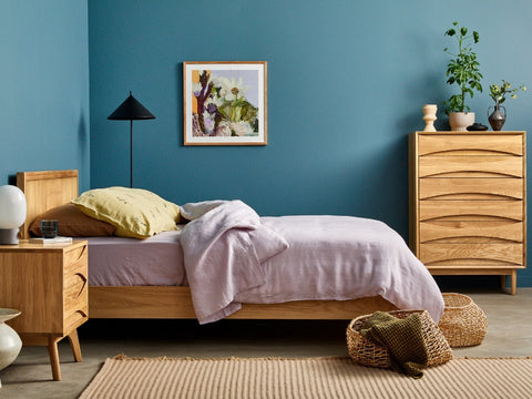 oak bed and drawers with blue wall